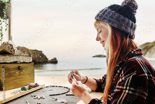 Smiling craftswoman creating bijouterie in van photo