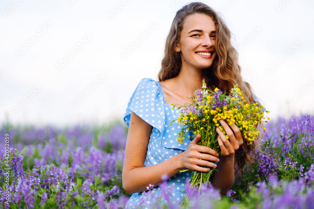 Portrait of beautiful woman in amazing in a blooming field. Nature, vacation, relax and lifestyle. Summer landscape.