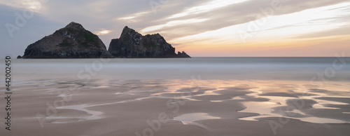 Absolutely stunning landscape images of Holywell Bay beach in Cornwall UK during golden hojur sunset in Spring
