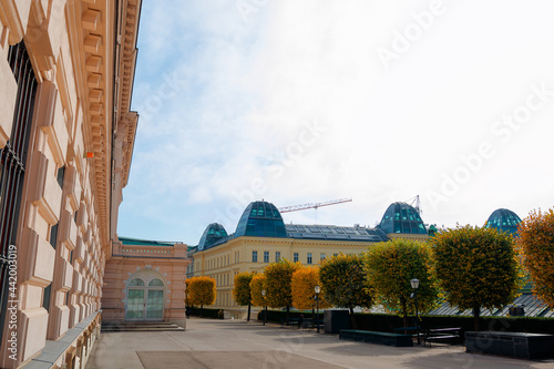 vienna, austria - OCT 17, 2019: terrace on the backside of albertina museum building. cafe and restaurant place. benches under the trees in fall foliage. sunny afternoon photo