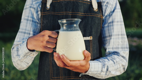 Bilde på lerret The farmer holds a jug with milk. Organic products concept