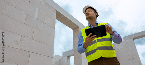 Картината върху платно construction project monitoring - engineering supervisor working with digital tablet at building site