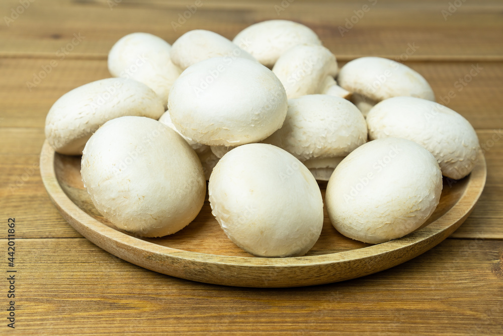 Raw or fresh mushroom champignons on wooden table. Raw or fresh mushroom champignons on wooden table.