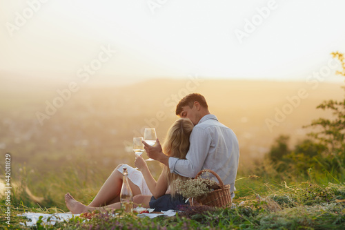 Young couple enjoying picnic and time together on the mountain on summer vacations.