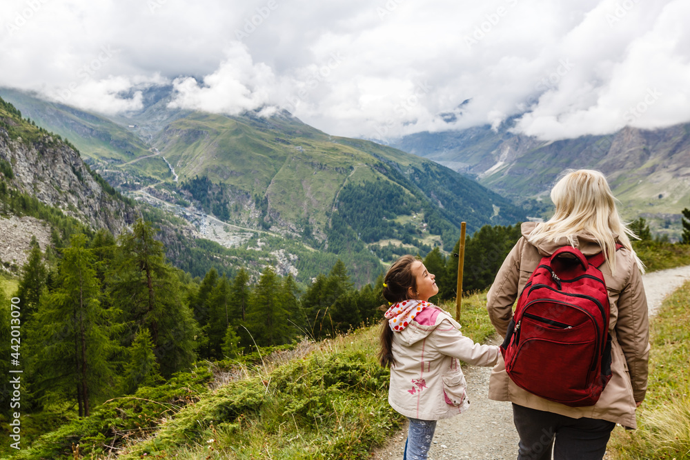 Naklejka premium Mother and to children going for a walk in mountain surroundings