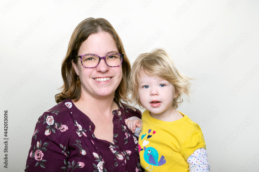 mother with her two year old daughter photographed in studio on a white background mother with her two year old daughter photographed in studio on a white background