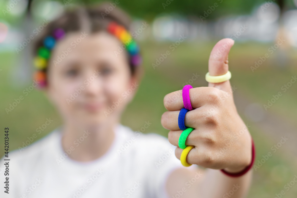 girl with colorful elastic bands on her finger show thumb up symbol everything is ok, LGBTQ theme girl with colorful elastic bands on her finger show thumb up symbol everything is ok, LGBTQ theme