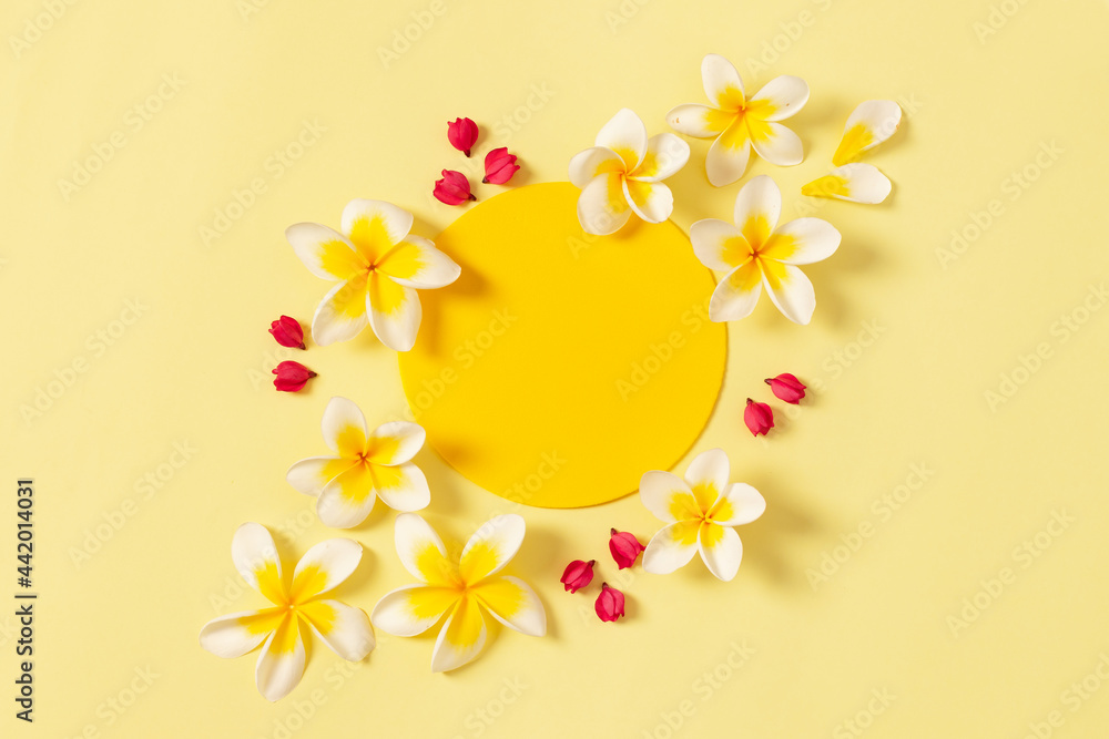 Round Frame from red flowers in the form of the sun on yellow background. Flat Lay