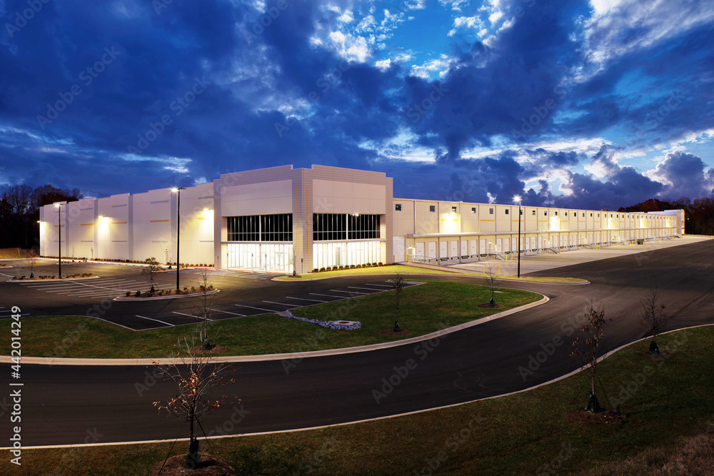 Exterior of white generic business warehouse industrial building at sunset