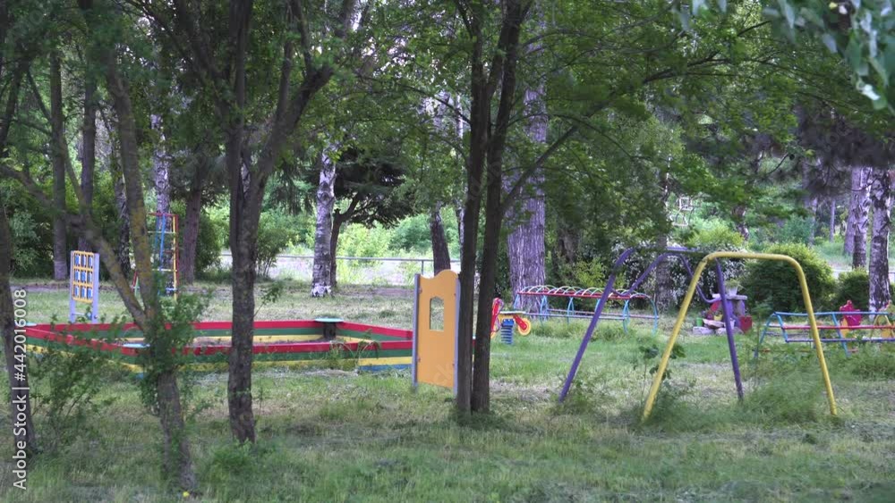 Children playground that haven't been cleaned and maintained for months. High grass and weeds and a lot of ticks and insects. Concept of neglecting, bad work, abandonment and kids danger. Children playground that haven't been cleaned and maintained for months. High grass and weeds and a lot of ticks and insects. Concept of neglecting, bad work, abandonment and kids danger.