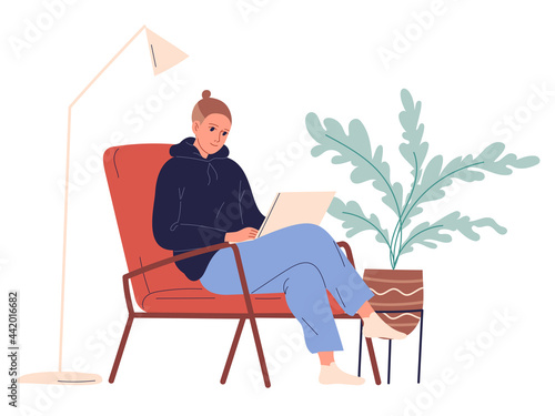 Young man sits in a chair with a laptop computer