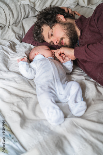 Wallpaper Mural Father with newborn baby resting on crumpled bed at home Torontodigital.ca