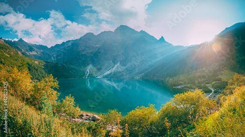 Fototapeta Naklejka Na Ścianę i Meble -  Tatra National Park, Poland. Famous Mountains Lake Morskie Oko Or Sea Eye Lake In Summer Evening. Beautiful Sunset Sun Sunshine Sunrays Above Tatras Lake Landscape