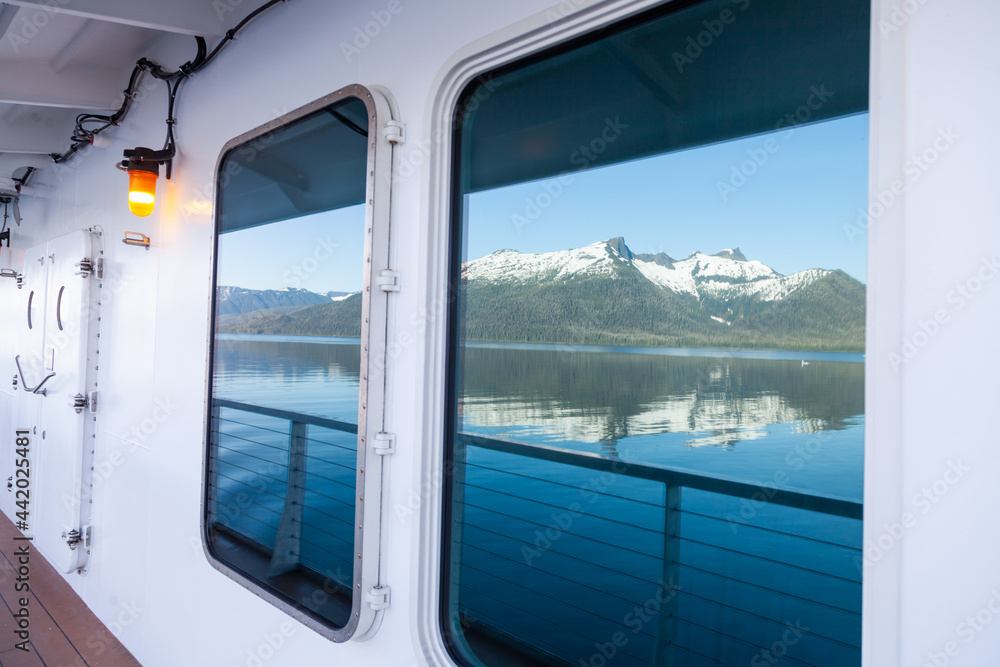 Landscape reflection in window of ship