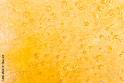 golden background of marijuana wax close-up, cannabis dab texture