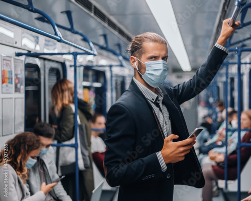 passenger in a protective mask standing in a subway car.