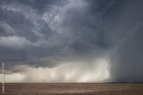 A severe storm with an intense precipitation shaft dumps rain and hail over the flat landscape of Kansas. photo