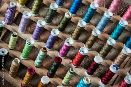 Multiple rows of colorful spools of thread