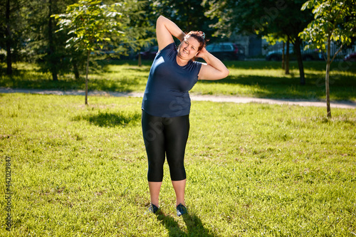 Physical training of fat femme on nature, ground acrobatics or parterre stretching.
