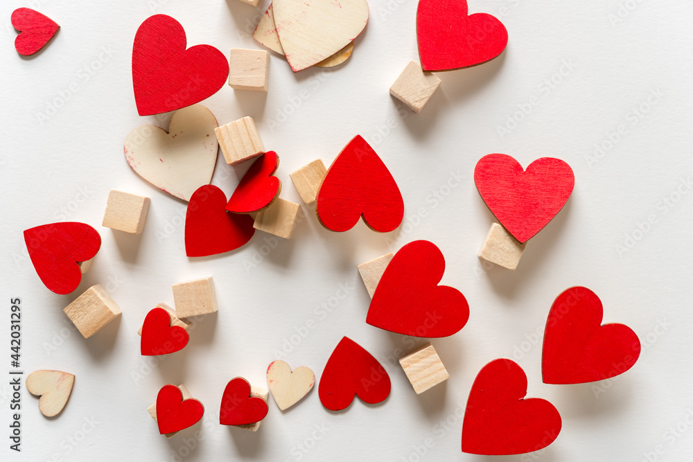 tumbling hand painted red hearts and untreated wood craft cubes on a light background tumbling hand painted red hearts and untreated wood craft cubes on a light background