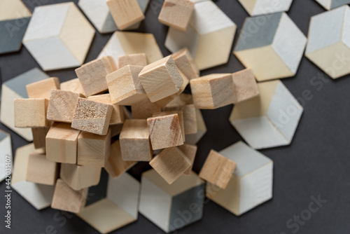 untreated wood craft cubes and painted trompe l oeil  hexagonal  cubes on dark gray background