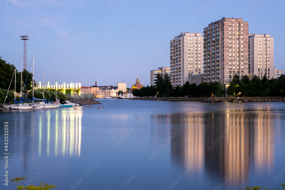 Modern highrise apartment buildings casting reflections on the water surface.