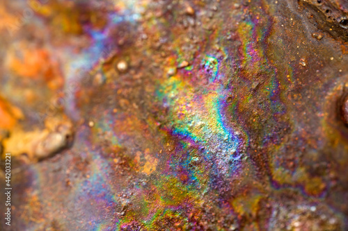 Abstract irridescent rainbow rusted orange and brown metal surface photo
