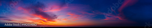 Dramatic wide panorama of late sunset with burning sky