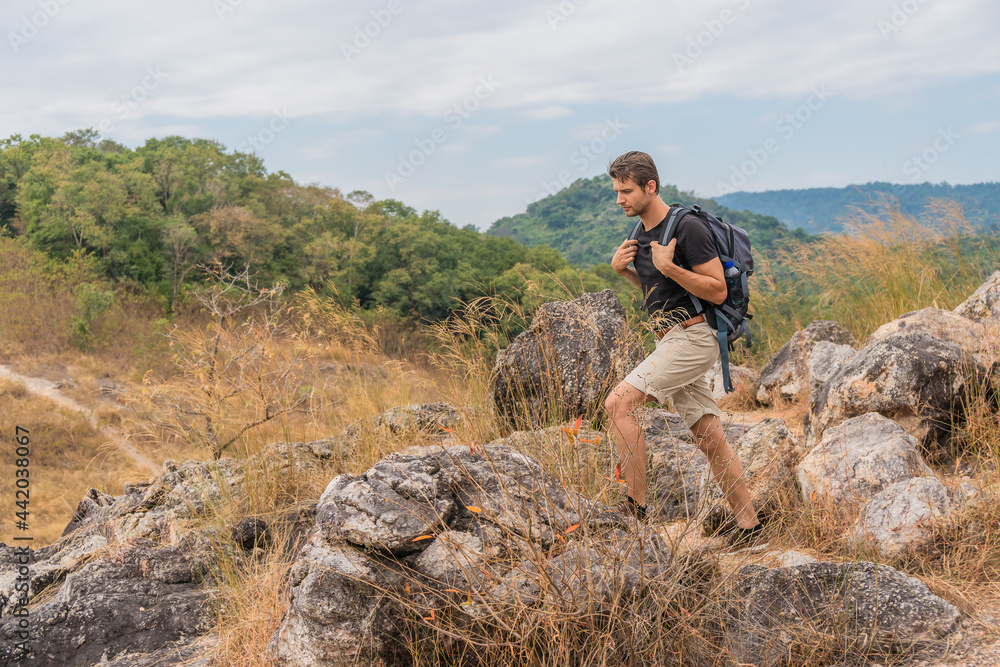 hiker walking on trekking trail on rocky hill on mountain