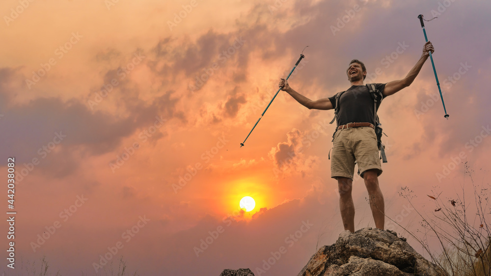hiker with trekking stick hiking success on rocky hill top at sunset sky hiker with trekking stick hiking success on rocky hill top at sunset sky