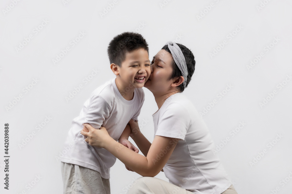 Young adult female cancer patient spending time with little son on gray background. Cancer and family support concept. Young adult female cancer patient spending time with little son on gray background. Cancer and family support concept.