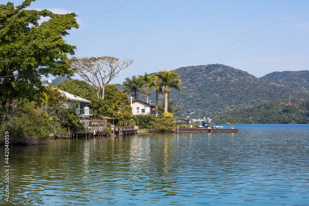 Paisagem de lago e colina com floresta.