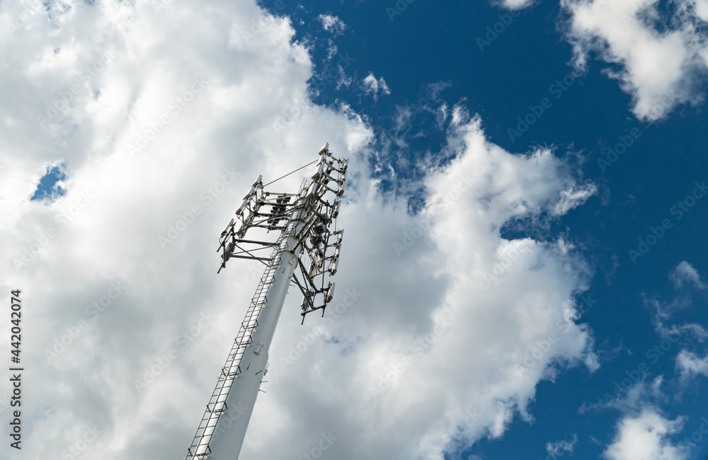 Fototapeta premium Mobile phone communication radio antenna, 3G, 4G, 5G, 6G. Antenna over cloudy blue sky at summer. Cellular GSM tower with transmitter. Telecommunication base station network.
