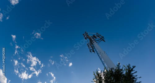 Mobile phone communication radio antenna, 3G, 4G, 5G, 6G. Antenna over cloudy blue sky at summer. Cellular GSM tower with transmitter. Telecommunication base station network. photo
