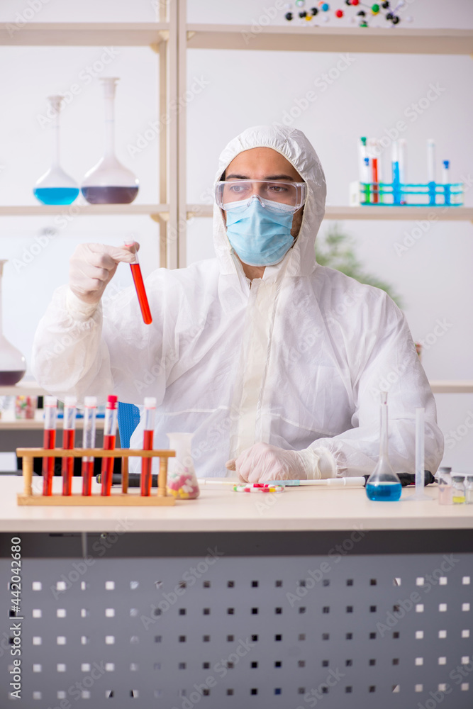Young male chemist in drugs syntesis concept Young male chemist in drugs syntesis concept