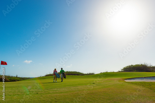 Active senior couple playing golf.