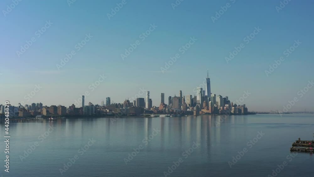 A drone view of the Hudson River from the NJ side early in the morning. The camera dolly out over the calm river and empty piers with lower Manhattan in the distance. A drone view of the Hudson River from the NJ side early in the morning. The camera dolly out over the calm river and empty piers with lower Manhattan in the distance.
