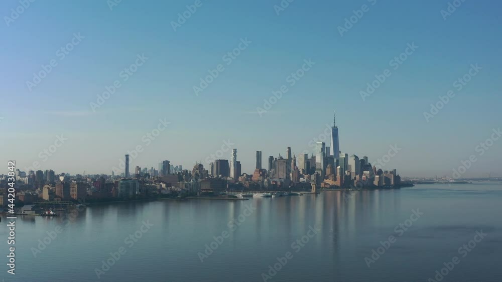 A drone view of the Hudson River from the NJ side early in the morning. The camera dolly out over the calm river, with no boats, no activity with lower Manhattan in the distance. A drone view of the Hudson River from the NJ side early in the morning. The camera dolly out over the calm river, with no boats, no activity with lower Manhattan in the distance.