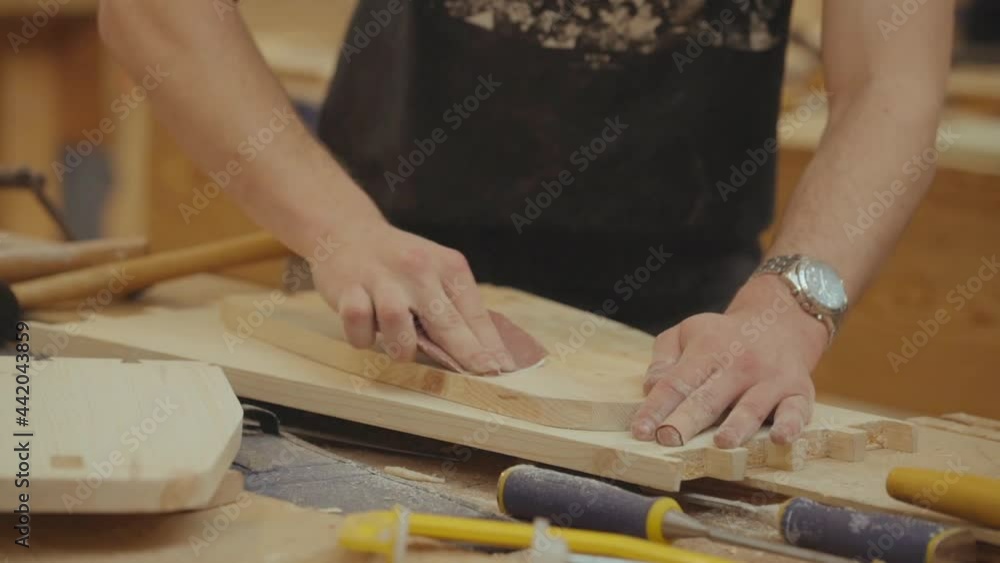 Close-up of a carpenter's using sandpaper to smooth a wooden table. Real time Close-up of a carpenter's using sandpaper to smooth a wooden table. Real time