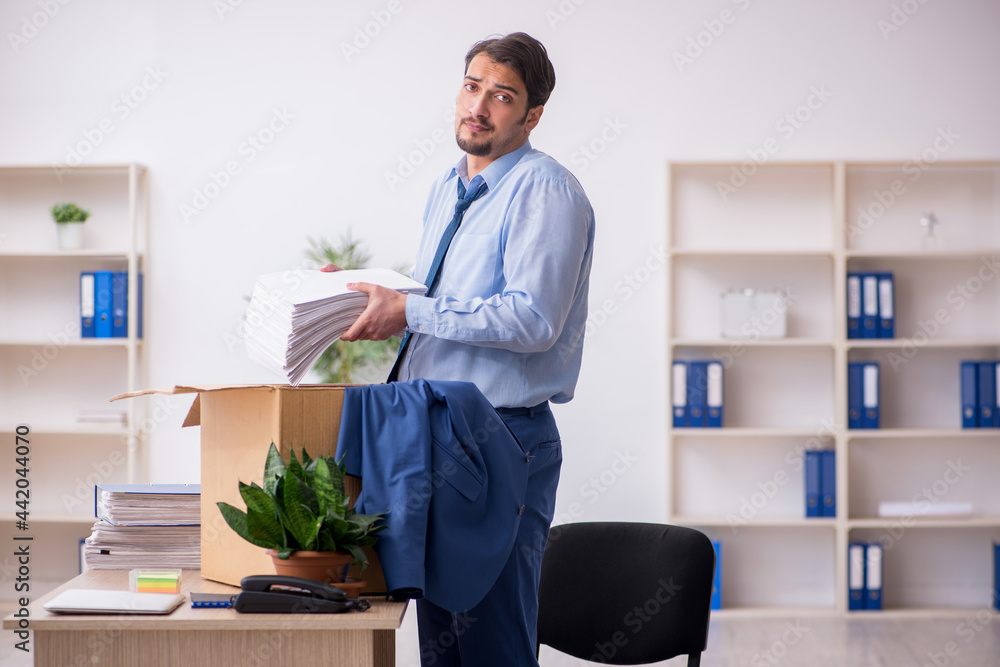 Young male employee in business relocation concept Young male employee in business relocation concept