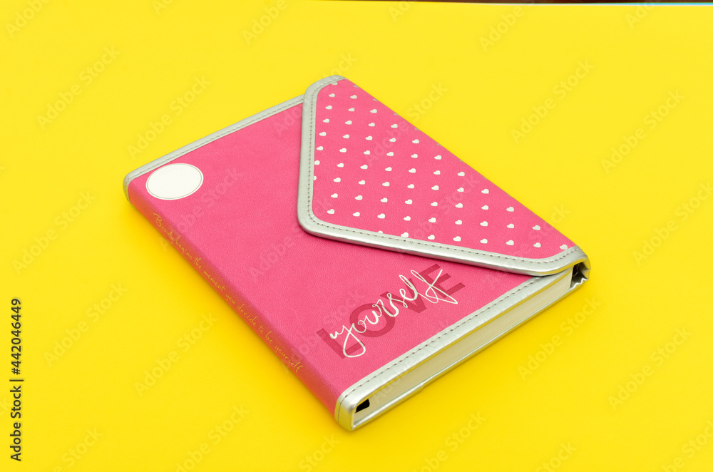 Agenda personal de color rosa sobre fondo aamrillo. Agenda personal de color rosa sobre fondo aamrillo.