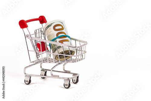 shopping cart with 100 dollars banknotes on white background © MasterSergeant