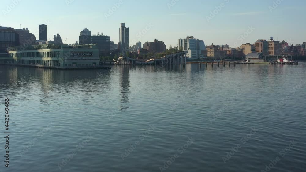 a drone view over a calm and empty Hudson River on a sunny day. The camera dolly in just over the water towards Manhattan and the piers on the west side of the island. a drone view over a calm and empty Hudson River on a sunny day. The camera dolly in just over the water towards Manhattan and the piers on the west side of the island.