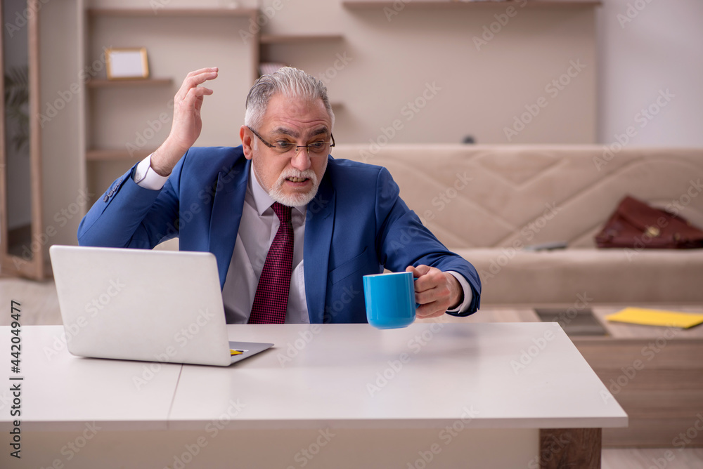 Old male employee working from home during pandemic Old male employee working from home during pandemic