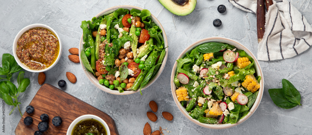 Assorted vegan salads on dark gray background. Seasonal food concept.