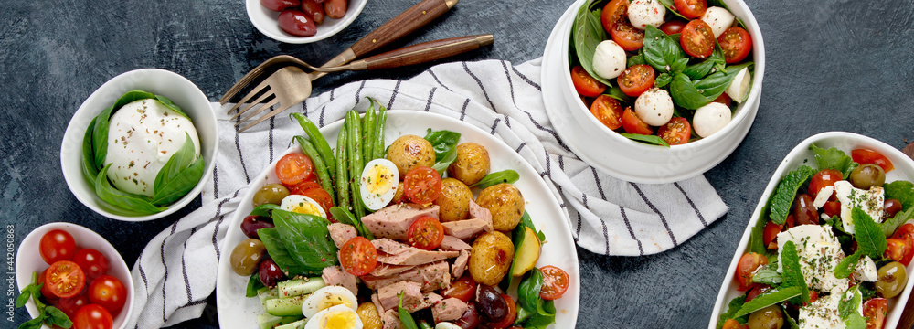 Assorted salads on dark gray background. Seasonal food concept. Assorted salads on dark gray background. Seasonal food concept.