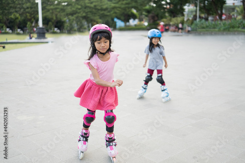 two asian girl going on her in-line skates in the park