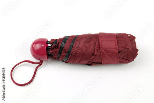 Dark red foldable umbrella on white compact, easy to carry