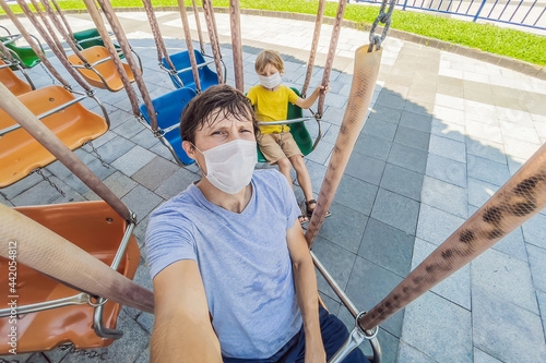 Family wearing a medical mask during COVID-19 coronavirus at an amusement park