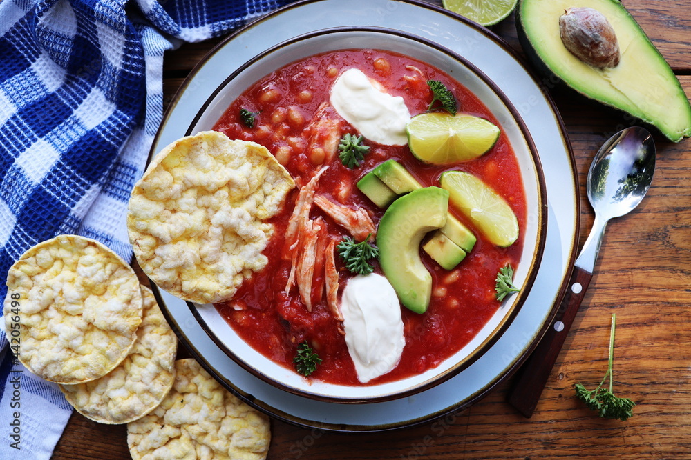 Chicken tortilla chili soup with beans, avocado, lime, . Mexican traditional dish